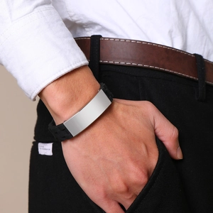Close-up of a men's black silicone bracelet with a blank silver stainless steel plate