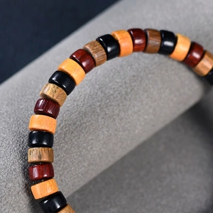 Multi-colored wooden beaded bracelet featuring polished sandalwood discs on a display stand