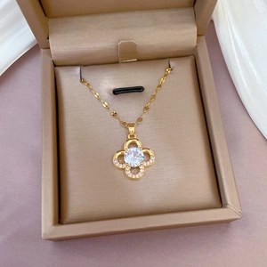 Gold titanium steel four-leaf clover necklace with sparkling cubic zirconia in a jewelry box
