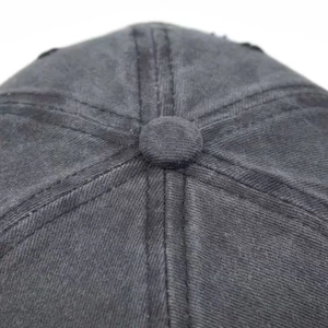 Close-up of top button and stitching detail on dark grey washed cotton USA baseball cap