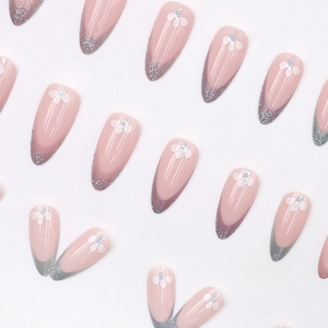 Faux ongles amande rose avec pointes françaises pailletées argent et motifs de fleurs