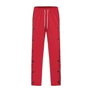 Detail of red joggers featuring side plaid panels and black metal snap buttons