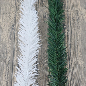 White and dark green PVC pine needle garlands on wood background for holiday decoration