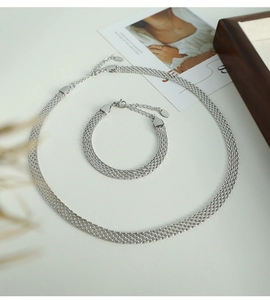 Detailed close-up of a silver multilayer mesh chain necklace and bracelet set