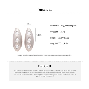 Detailed view of silver matte geometric oval earrings with inlaid pearls and dimensions