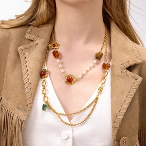 Collana boho a strati con catene dorate, pietre colorate in resina e perle indossata da modella