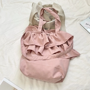 Detail view of pink ruffled tote bag with delicate layered frills and durable straps