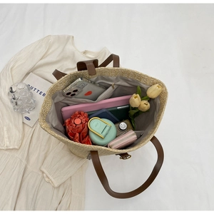 Overhead view of large straw tote bag showing spacious interior and brown leather straps