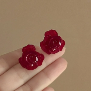 Elegante mehrlagige rote Rosen-Ohrstecker im Urlaubsstil, in der Hand präsentiert