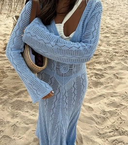 Détails d'une robe en crochet bleu clair avec motifs floraux tricotés et décolleté en V