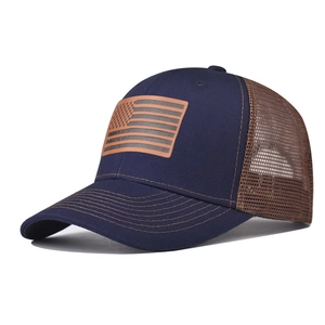 Dettaglio cappello trucker blu con rete marrone e toppa in pelle bandiera USA