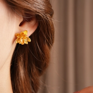 Macro-opname van gouden lotusbloem oorknopjes elegant gedragen door een model