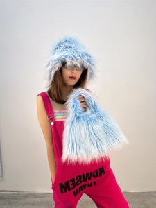 Detail of light blue faux fur bucket hat and matching plush handbag with pink overalls