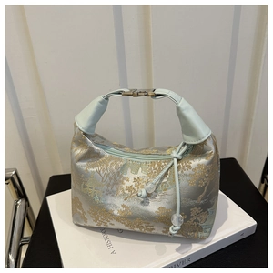 Detail of light blue Chinese brocade handbag with mountain landscape pattern and bead pulls
