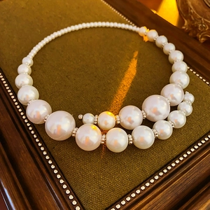 Detail showing gradient sized faux pearl necklace with warm vintage lighting effects
