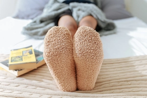 Close-up of cozy brown coral fleece socks on feet for a warm home comfort feeling