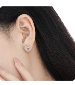 Close-up of minimalist S925 silver stud earring with irregular frame and clear gemstone