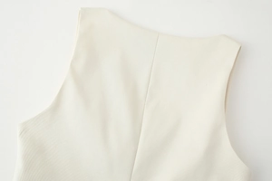 Macro detail of the back seam and textured fabric on the cream sleeveless square neck vest