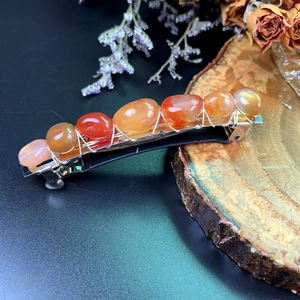Bohemian crystal spring hair clip with orange agate stones on rustic wood background