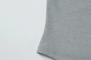 Gros plan sur un tricot côtelé gris montrant la texture du tissu et les finitions de couture