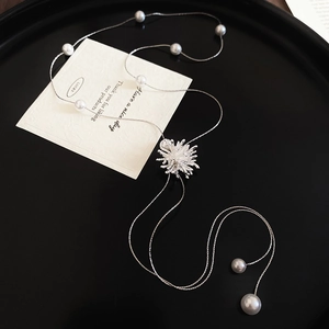 Vue macro du pendentif flocon en zircon argenté avec perles élégantes sur fond noir