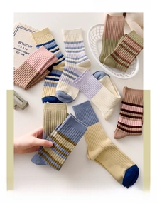 Detalle de calcetines de algodón con rayas vintage y puños acanalados en colores cálidos