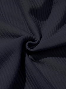 Macro shot of dark navy ribbed knit fabric showing detailed corduroy texture and drape