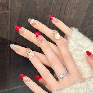 Handmade red and gold press-on nails with 3D snowflake charms and glitter finish