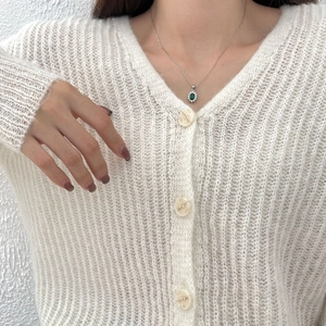925 sterling silver necklace with oval green zircon halo pendant worn on white knitwear