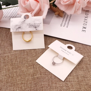 Detail view of gold and silver rings on white display cards with marble patterns
