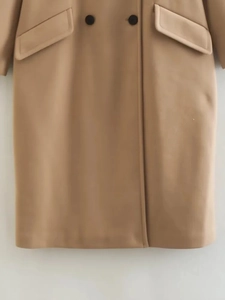 Detail view of the camel wool coat featuring double-breasted buttons and side flap pockets