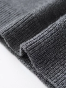 Close-up of dark grey ribbed knit fabric showing detailed texture of the hem and fibers