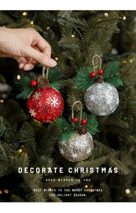Detail of Christmas ornament balls with glitter snowflakes, pine cones, and berries