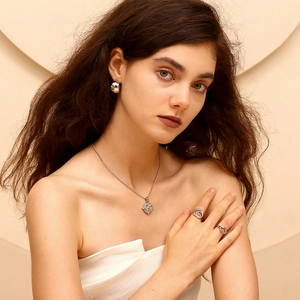 Modella che indossa set di gioielli in argento con collana e anelli a spirale