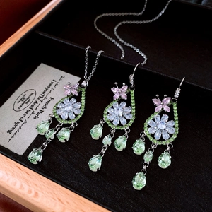 Détail de parure collier et boucles d'oreilles fleur avec pierres gouttes vertes