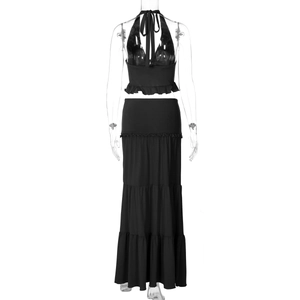 Detailed view of black two-piece set featuring a halter neck top and tiered maxi skirt