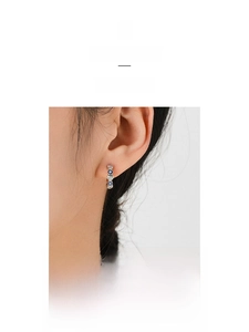 Detail of silver heart hoop earrings with blue evil eye beads and sparkling zircons