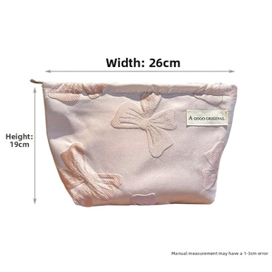 Detailed view of canvas makeup bag with bow texture measuring 26cm width and 19cm height