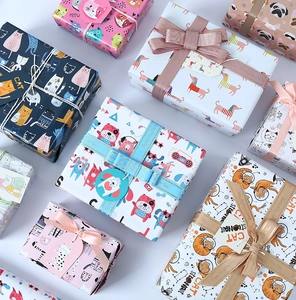 Flat lay of colorful gift wrapping paper featuring cartoon cat and dog patterns with tags