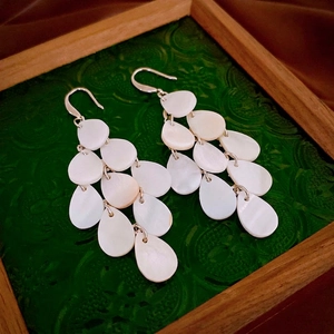 Vintage layered white shell teardrop earrings with silver hooks on green glass