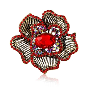 Vintage gold-tone flower brooch with red rhinestones and oval center stone