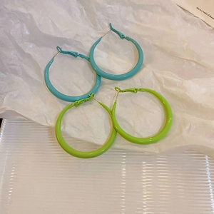 Minimalist geometric hoop earrings with vibrant blue and green enamel finish in lifestyle setting