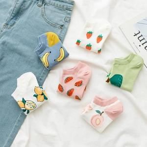 Detail shot of cute fruit patterned cotton boat socks on soft white fabric background