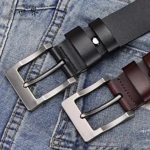 Detail of vintage embossed leather belts with brushed metal buckles on denim