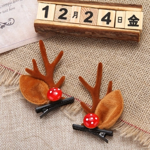 Detalle de pinzas para pelo de asta de reno marrón con decoración de hongo rojo