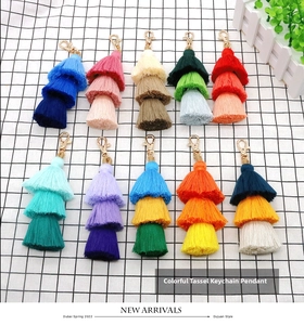 Detailed view of ten colorful three-layer tassel keychains with gold lobster clasps