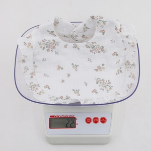 Detailed view of lightweight cotton gauze baby bib with floral print weighing only 22 grams