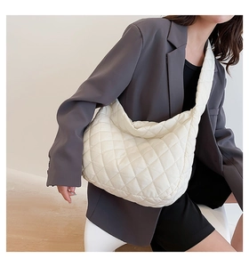 Professional shot of a white quilted puffer shoulder bag with diamond stitch detail