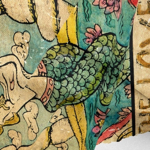 Macro detail of thick vintage tarot tapestry fabric showing mermaid and lotus patterns