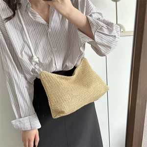 Minimalist woven straw crossbody bag with white faux leather knot strap on model
